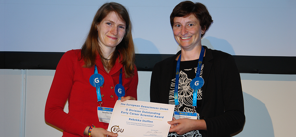 Rebecka Steffen, till vänster, tar emot priset av Annette Eicker, ordförande för EGU:s geodesidivision, till höger i bilden.