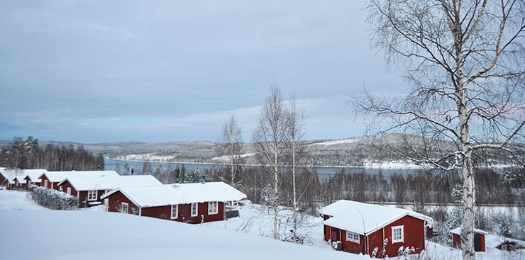 Stugor på en sluttning i ett vinterlandskap.