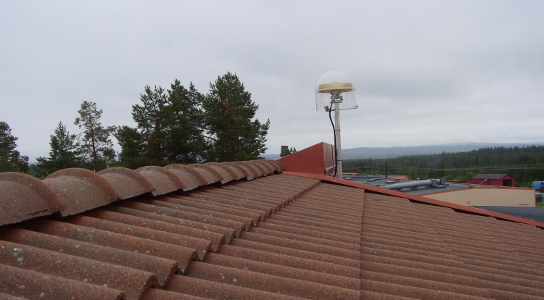 GNSS-antennen på klass B-stationen i Storuman syns ovanför taket på den byggnad där den är monterad.